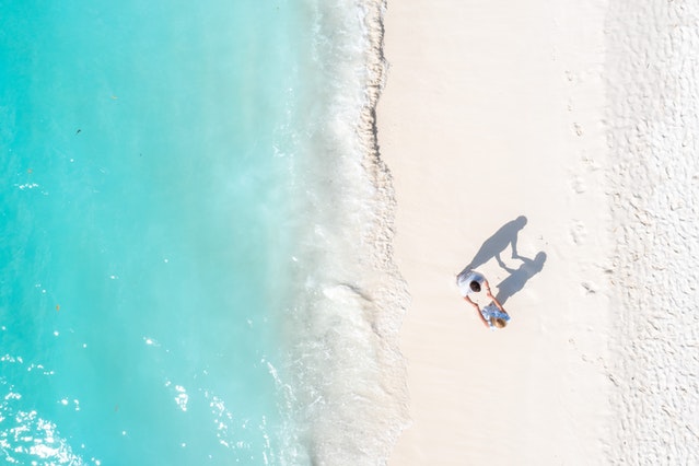 A couple holding hands on the beach.