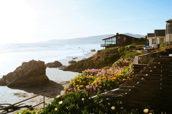 A beautiful brown house on a beach in the morning sky 