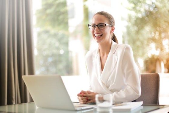 woman working on her laptop and smiling 